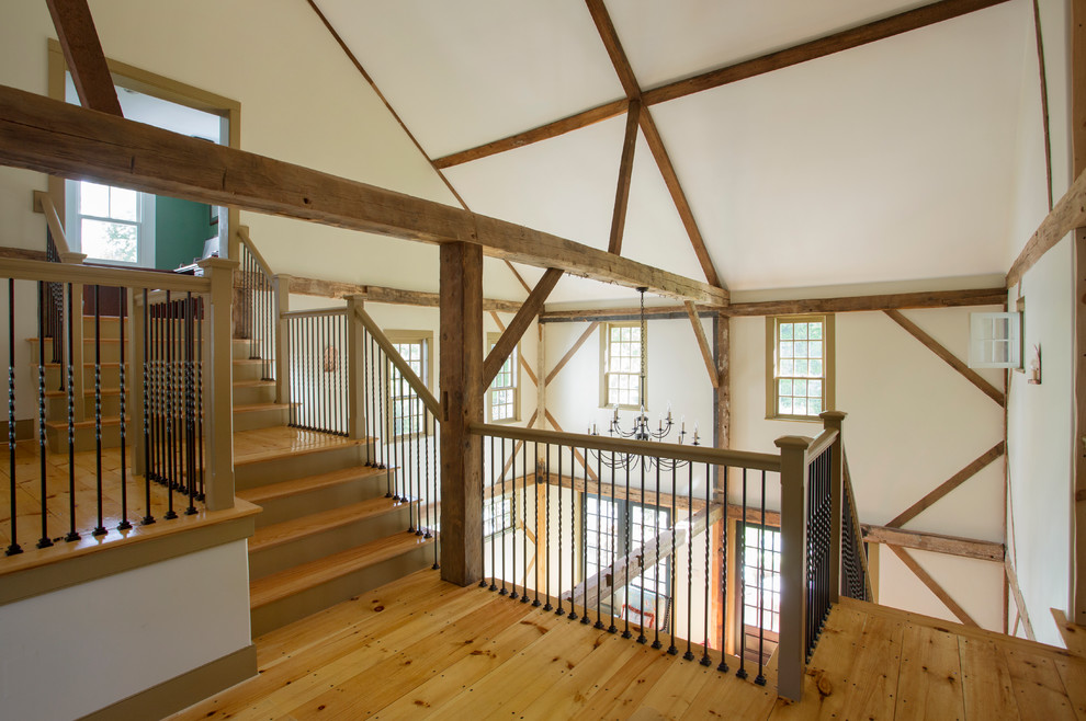 Imagen de sala de estar con biblioteca tipo loft de estilo de casa de campo grande sin televisor con paredes blancas y suelo de madera clara