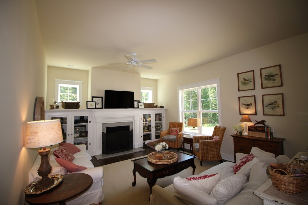 Mittelgroßes, Offenes Landhausstil Wohnzimmer mit beiger Wandfarbe, braunem Holzboden, Kamin, Kaminumrandung aus Stein und TV-Wand in Richmond