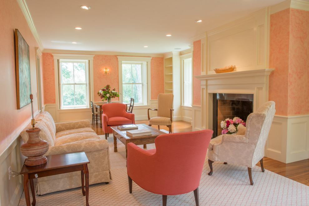 На фото: гостиная комната в классическом стиле с розовыми стенами