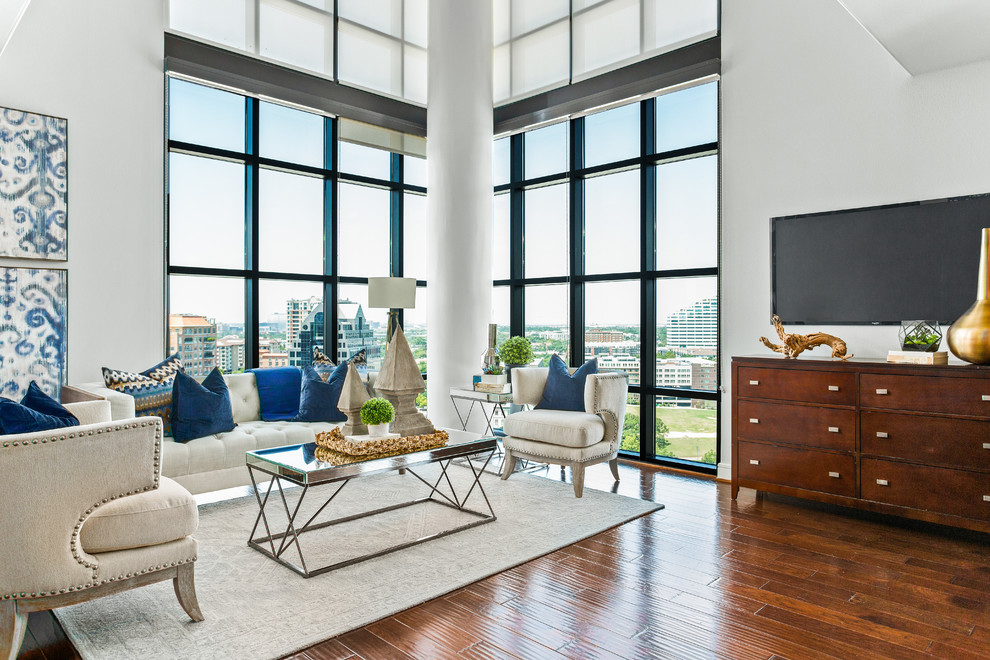 This is an example of a classic open plan living room in Dallas with white walls, dark hardwood flooring and a freestanding tv.
