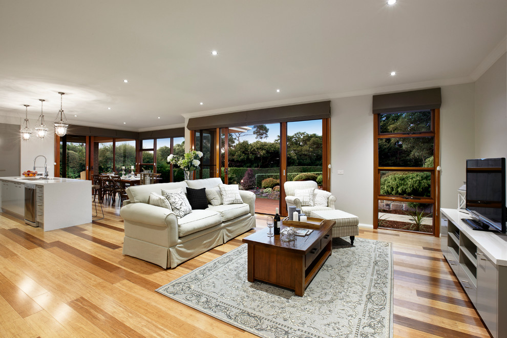 Foto di un soggiorno minimal di medie dimensioni e aperto con pareti beige, parquet chiaro e TV autoportante