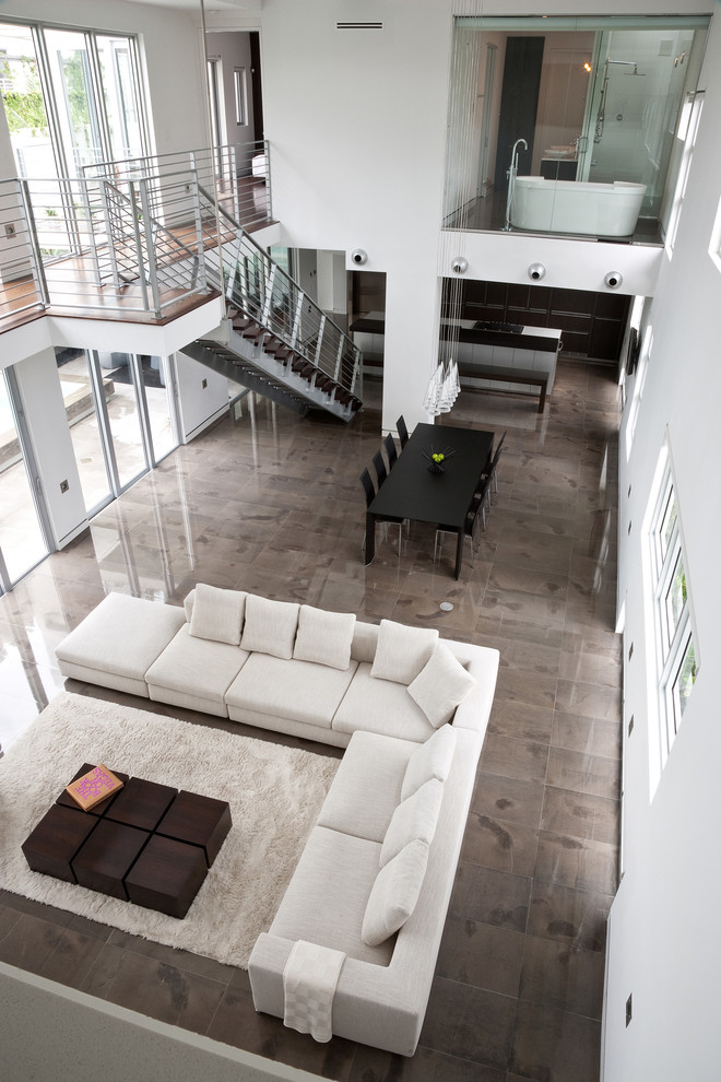 Family room - large modern open concept concrete floor family room idea in Miami with white walls and a wall-mounted tv