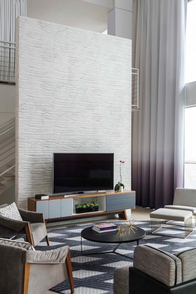 На фото: большая двухуровневая гостиная комната в современном стиле с белыми стенами, светлым паркетным полом, отдельно стоящим телевизором и коричневым полом