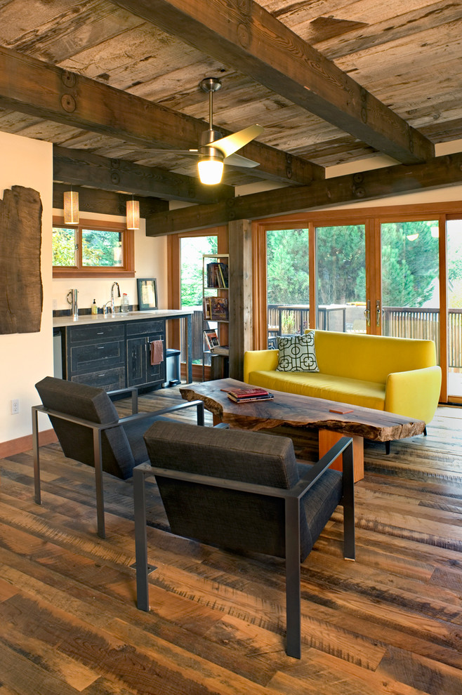 Cette photo montre une salle de séjour tendance avec un mur beige et parquet foncé.