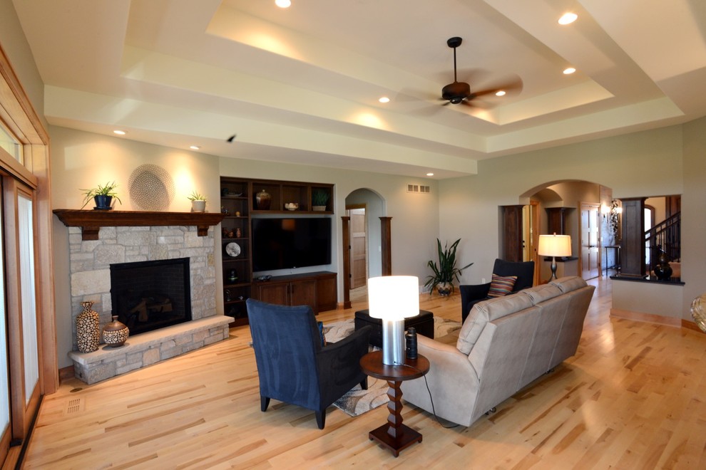 Large open concept light wood floor family room photo in Other with a standard fireplace, a stone fireplace and a media wall