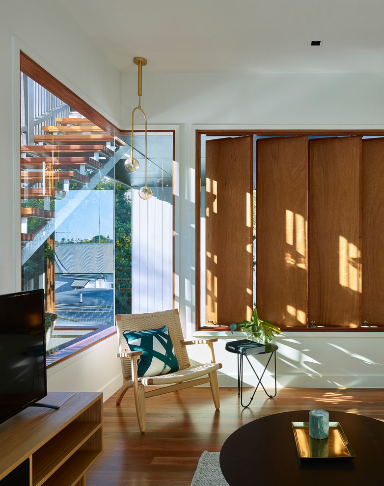 Mittelgroßes, Abgetrenntes Modernes Wohnzimmer ohne Kamin mit weißer Wandfarbe, braunem Holzboden, freistehendem TV und braunem Boden in Brisbane