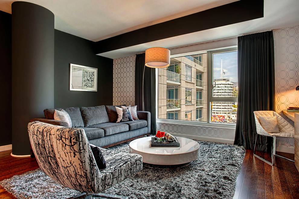 Diseño de sala de estar contemporánea sin chimenea y televisor con paredes negras y suelo de madera oscura