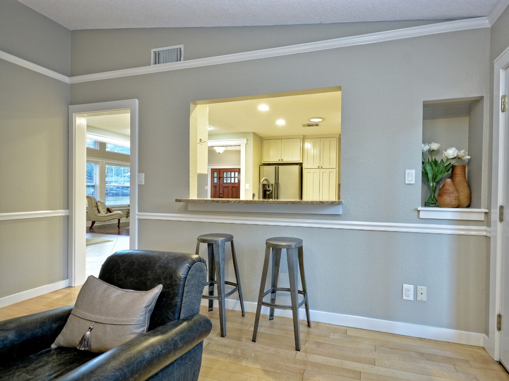 На фото: открытая гостиная комната среднего размера в стиле кантри с серыми стенами, светлым паркетным полом, стандартным камином и фасадом камина из кирпича