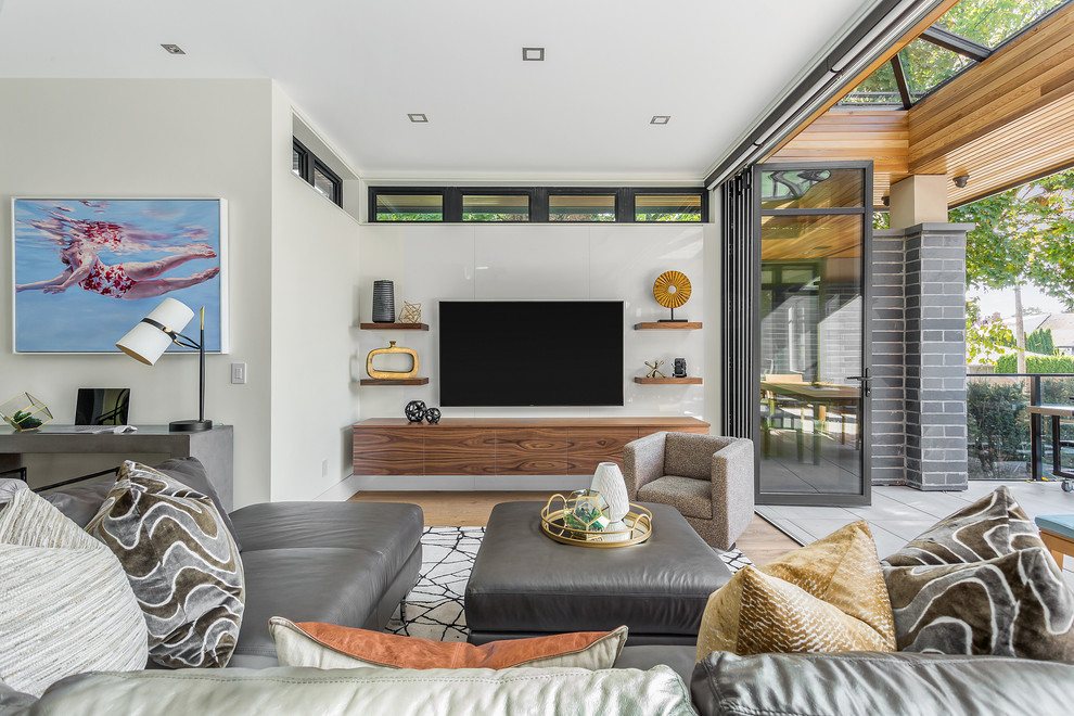 Aménagement d'une salle de séjour contemporaine de taille moyenne et ouverte avec un mur blanc, parquet clair, un téléviseur fixé au mur et un sol marron.
