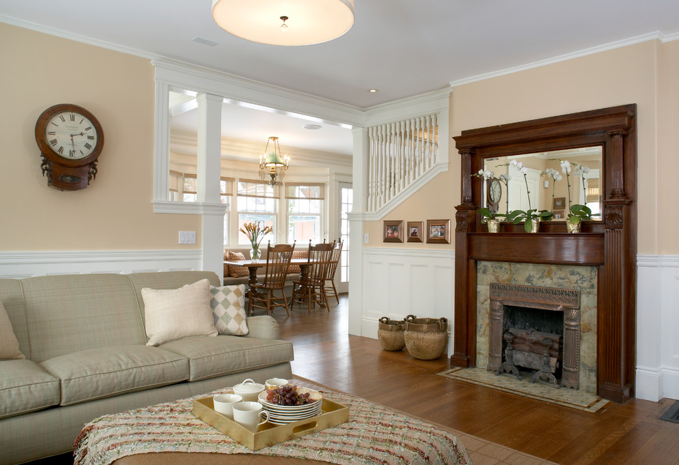 Exemple d'une salle de séjour chic de taille moyenne et fermée avec un mur beige, un sol en bois brun, une cheminée standard, un manteau de cheminée en carrelage et un téléviseur fixé au mur.