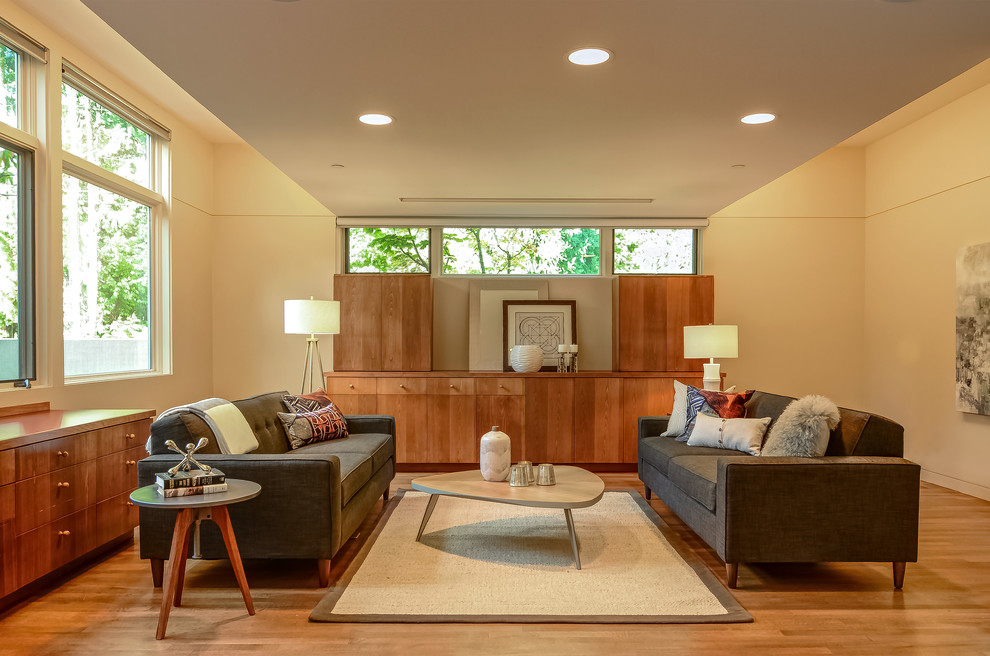 Example of a trendy medium tone wood floor family room design in Portland with beige walls