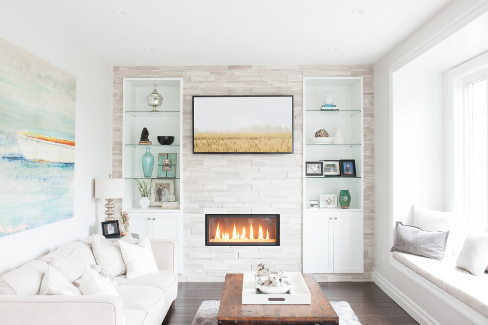 Inspiration for a medium sized classic open plan games room in Toronto with medium hardwood flooring, a ribbon fireplace, a tiled fireplace surround, a wall mounted tv, white walls and feature lighting.