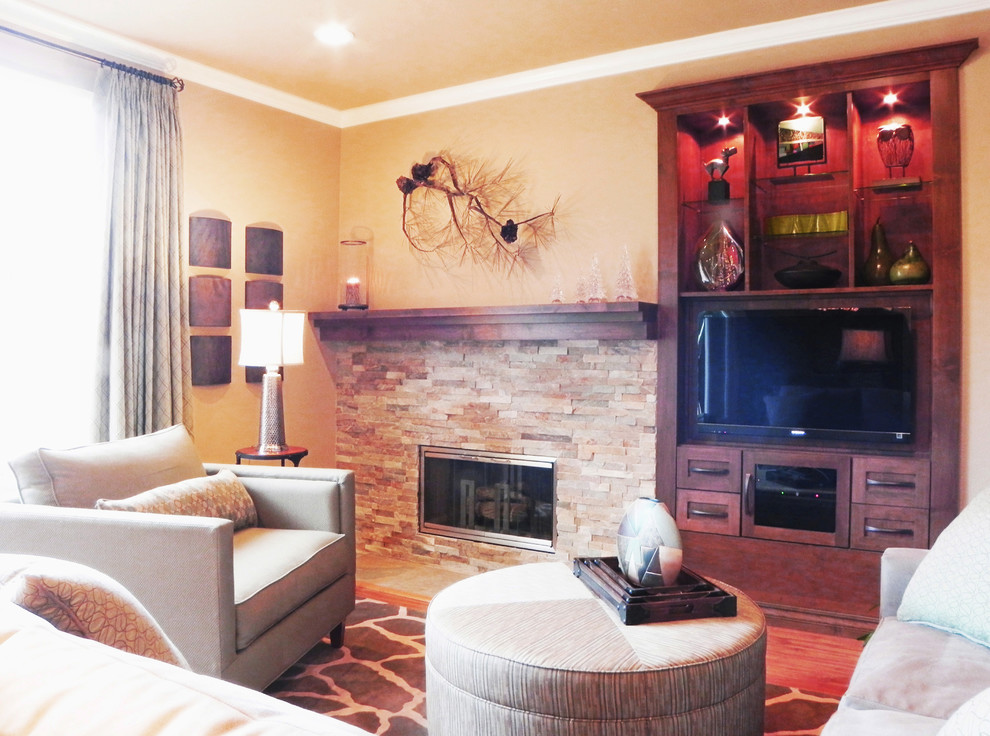 Cette photo montre une salle de séjour éclectique de taille moyenne et ouverte avec un mur beige, parquet clair, un téléviseur encastré, une cheminée standard et un manteau de cheminée en pierre.