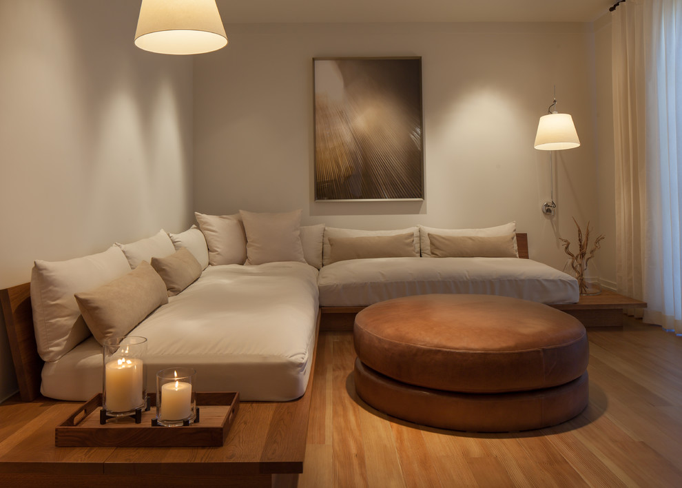 Immagine di un soggiorno chic con pareti beige, pavimento in legno massello medio e nessuna TV
