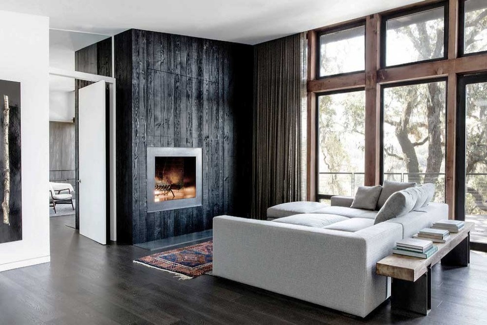 Medium sized urban open plan games room in San Francisco with white walls, dark hardwood flooring, a standard fireplace, a wooden fireplace surround, no tv and brown floors.