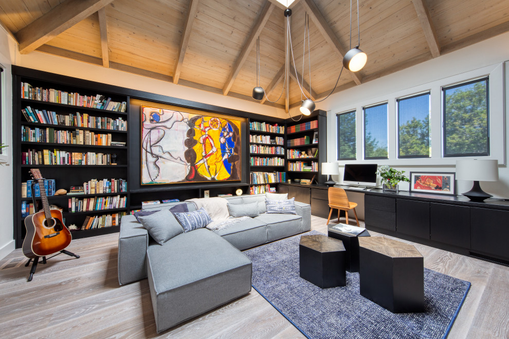 Family room library - large contemporary light wood floor and beige floor family room library idea in San Francisco with white walls