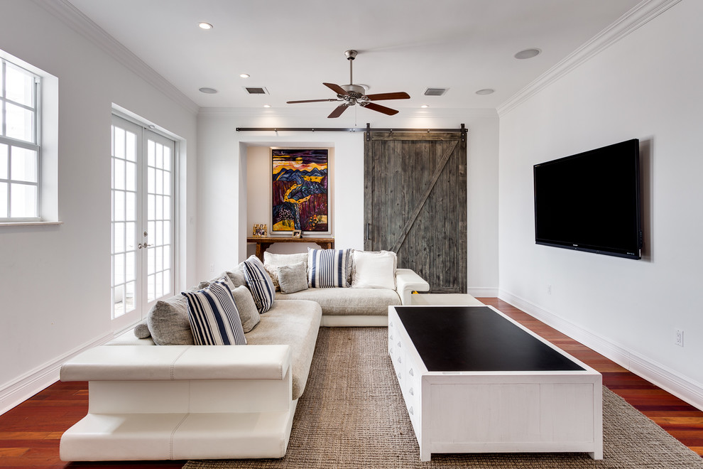 Foto de sala de estar tradicional renovada con paredes blancas, suelo de madera oscura, televisor colgado en la pared y suelo marrón