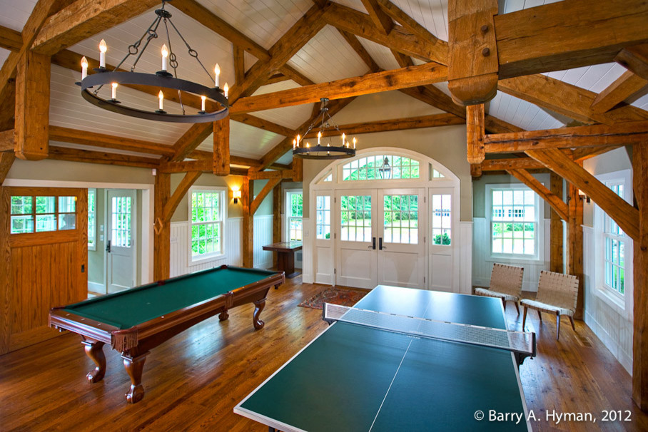 Medium sized classic games room in New York with a game room, medium hardwood flooring, a standard fireplace and a stone fireplace surround.