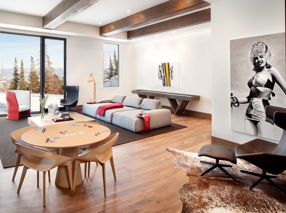 Immagine di un soggiorno design aperto con sala giochi, pareti bianche, parquet chiaro, nessun camino, nessuna TV e pavimento marrone