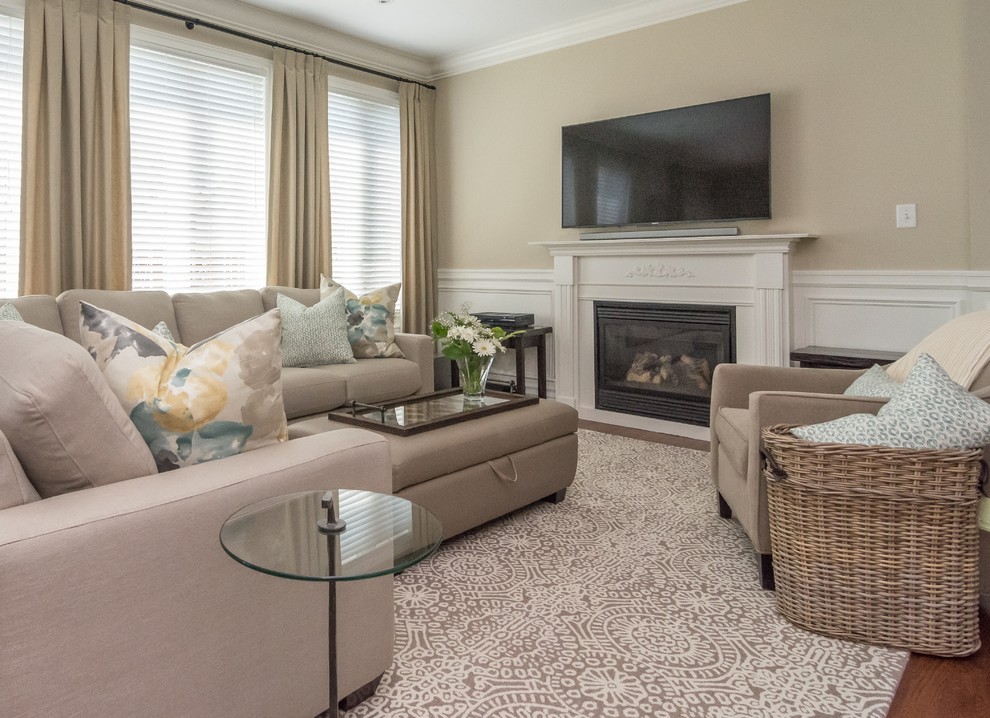 Imagen de sala de estar abierta clásica renovada grande con paredes beige, suelo de madera en tonos medios, todas las chimeneas, marco de chimenea de madera y televisor colgado en la pared