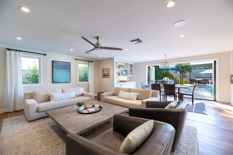 Immagine di un ampio soggiorno classico aperto con pavimento in legno massello medio, parete attrezzata e pavimento marrone