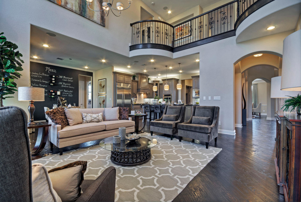 Example of a huge trendy open concept dark wood floor family room design in Dallas with beige walls, a standard fireplace and a wall-mounted tv