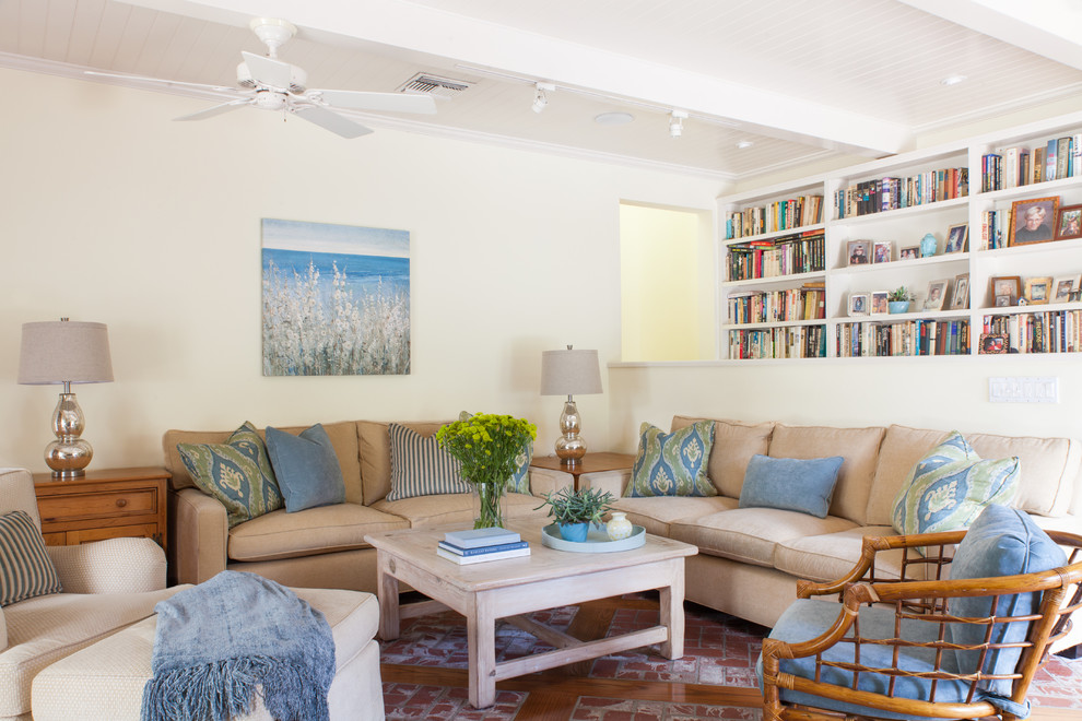 Ejemplo de sala de estar con biblioteca abierta tradicional renovada de tamaño medio con paredes amarillas, suelo de ladrillo y televisor independiente
