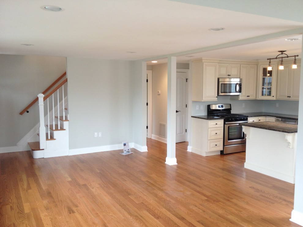 Modelo de sala de estar abierta de estilo americano pequeña con paredes grises y suelo de madera en tonos medios