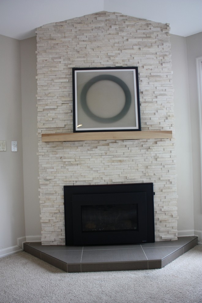Modelo de sala de estar moderna de tamaño medio sin televisor con paredes beige, moqueta, chimenea de esquina y marco de chimenea de piedra