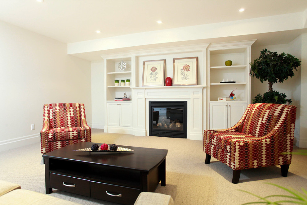 This is an example of a medium sized traditional basement in Toronto with beige walls, carpet, a standard fireplace and a metal fireplace surround.