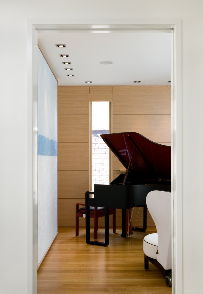 Bild på ett mellanstort funkis avskilt allrum, med ett musikrum, bruna väggar, mellanmörkt trägolv och brunt golv