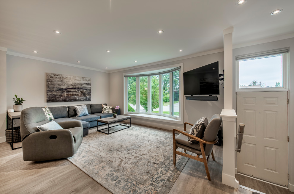 Immagine di un soggiorno minimal di medie dimensioni e aperto con pareti grigie, pavimento in legno massello medio, porta TV ad angolo e pavimento marrone