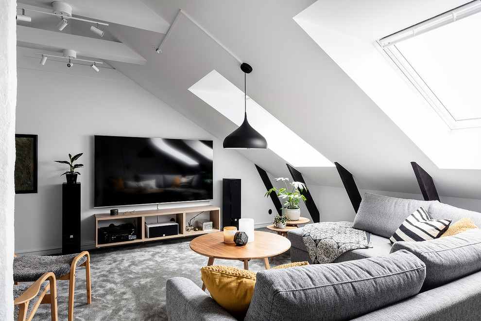 Inredning av ett nordiskt stort allrum på loftet, med vita väggar, heltäckningsmatta, en väggmonterad TV och beiget golv
