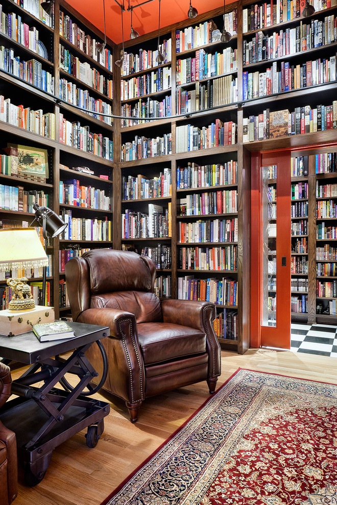 Пример оригинального дизайна: гостиная комната в классическом стиле с с книжными шкафами и полками, светлым паркетным полом и ковром на полу