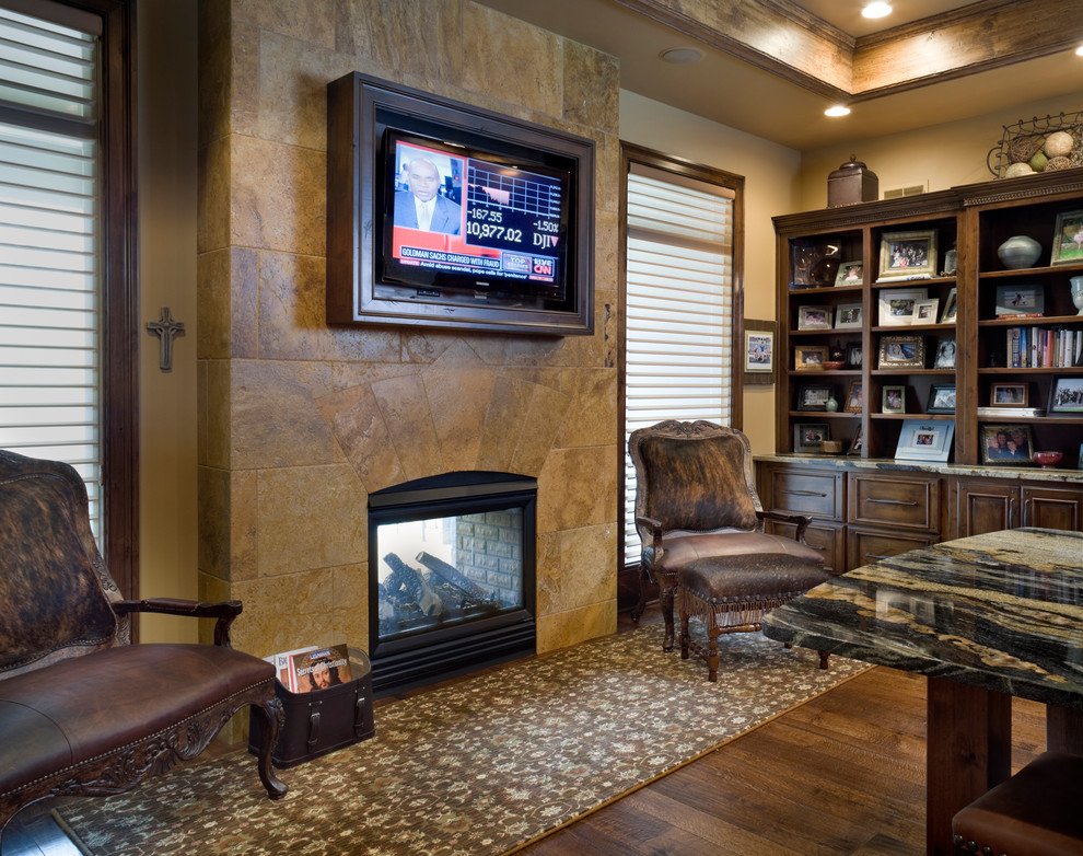 Inspiration for an expansive classic games room in Kansas City with beige walls, dark hardwood flooring, a two-sided fireplace, a stone fireplace surround and a built-in media unit.