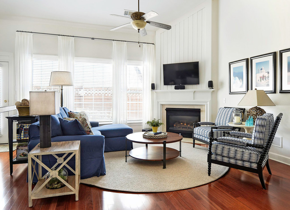 Ejemplo de sala de estar abierta clásica renovada con suelo de madera en tonos medios, chimenea de esquina, marco de chimenea de piedra y televisor colgado en la pared