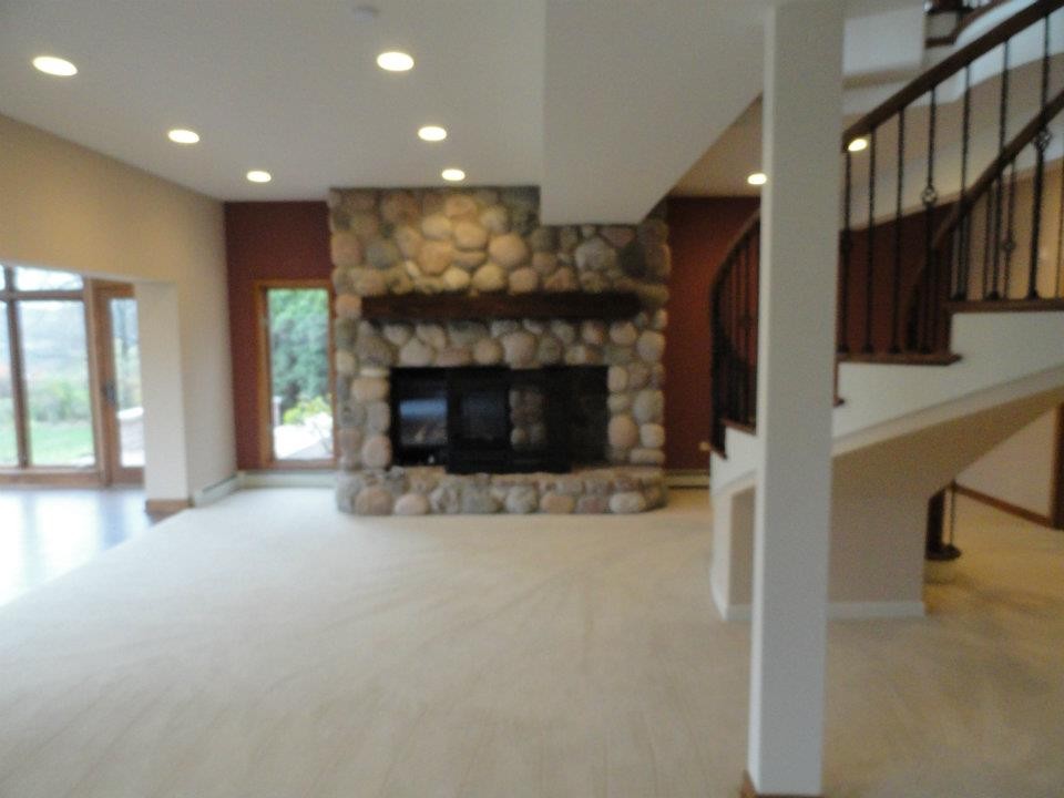 На фото: открытая гостиная комната среднего размера в стиле фьюжн с разноцветными стенами, ковровым покрытием, стандартным камином и фасадом камина из камня с