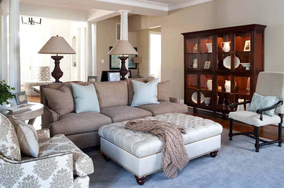Ejemplo de sala de estar abierta clásica de tamaño medio sin chimenea con paredes beige, suelo de madera en tonos medios y televisor colgado en la pared