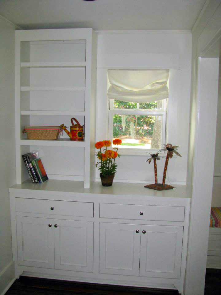 Diseño de sala de estar con biblioteca cerrada marinera de tamaño medio con paredes blancas, suelo de madera oscura y suelo marrón