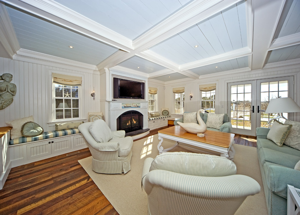 Inspiration for a timeless medium tone wood floor family room remodel in Boston with white walls, a standard fireplace and a wall-mounted tv