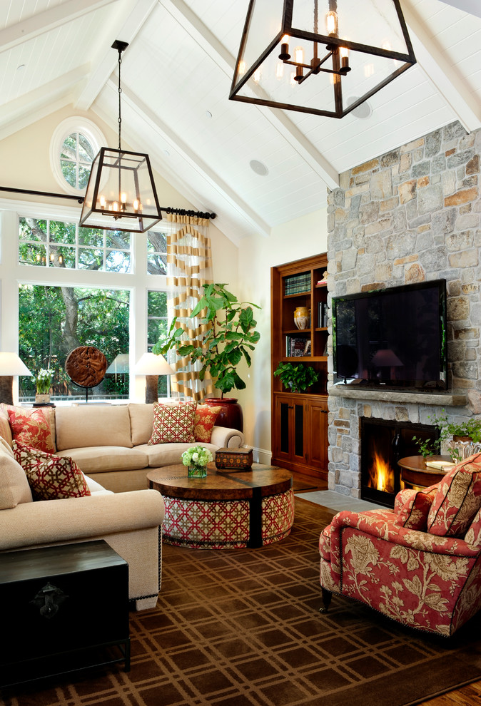 Diseño de sala de estar tradicional con paredes beige, todas las chimeneas y marco de chimenea de piedra