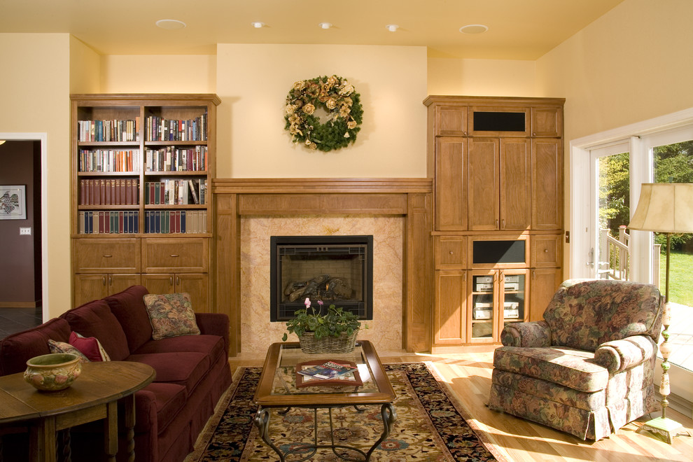 This is an example of a classic games room in Denver with beige walls, light hardwood flooring, a standard fireplace and no tv.