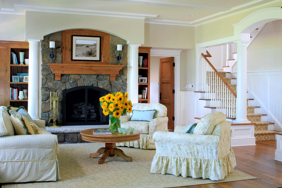 Fernseherloses Klassisches Wohnzimmer mit beiger Wandfarbe, braunem Holzboden, Kamin und Kaminumrandung aus Stein in Grand Rapids