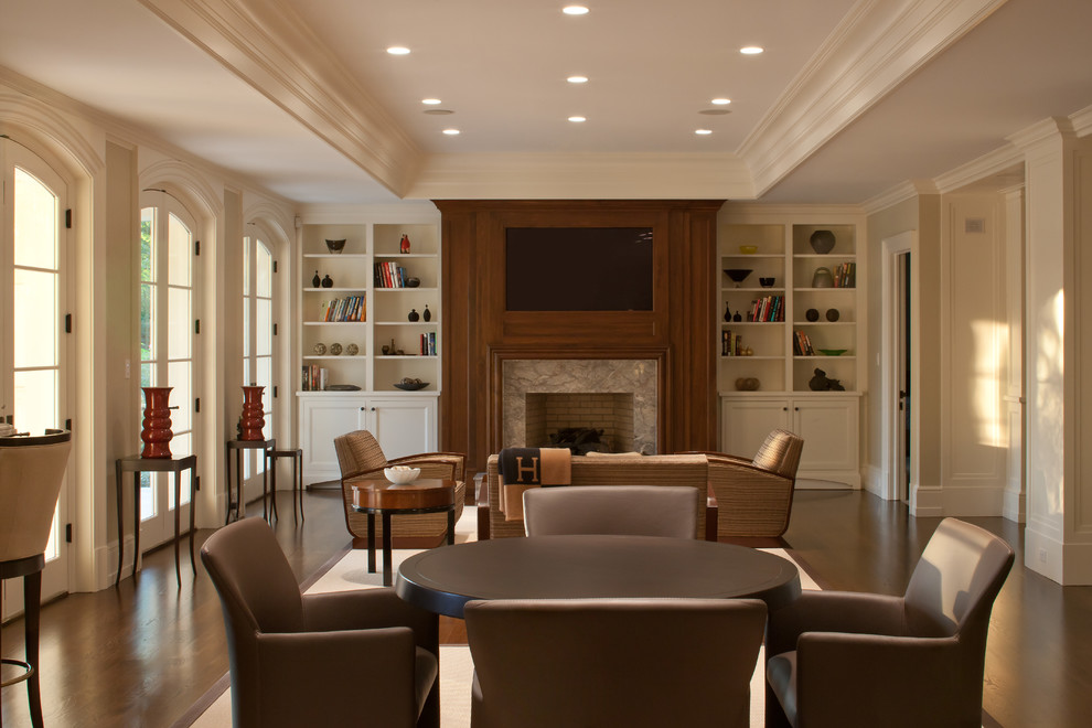 Ejemplo de sala de estar clásica con paredes beige, suelo de madera oscura, todas las chimeneas y televisor colgado en la pared