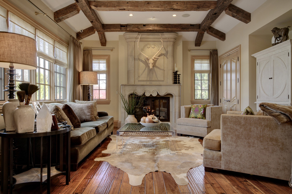 Imagen de sala de estar tradicional con paredes beige, suelo de madera en tonos medios, todas las chimeneas y marco de chimenea de piedra