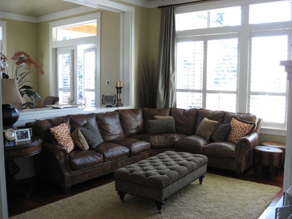 Diseño de sala de estar con barra de bar tipo loft tradicional de tamaño medio sin chimenea y televisor con suelo de madera en tonos medios y paredes marrones