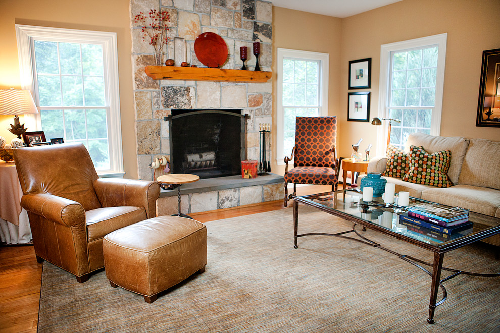 Diseño de sala de estar abierta clásica de tamaño medio sin televisor con paredes beige, suelo de madera en tonos medios, todas las chimeneas, marco de chimenea de piedra y suelo marrón