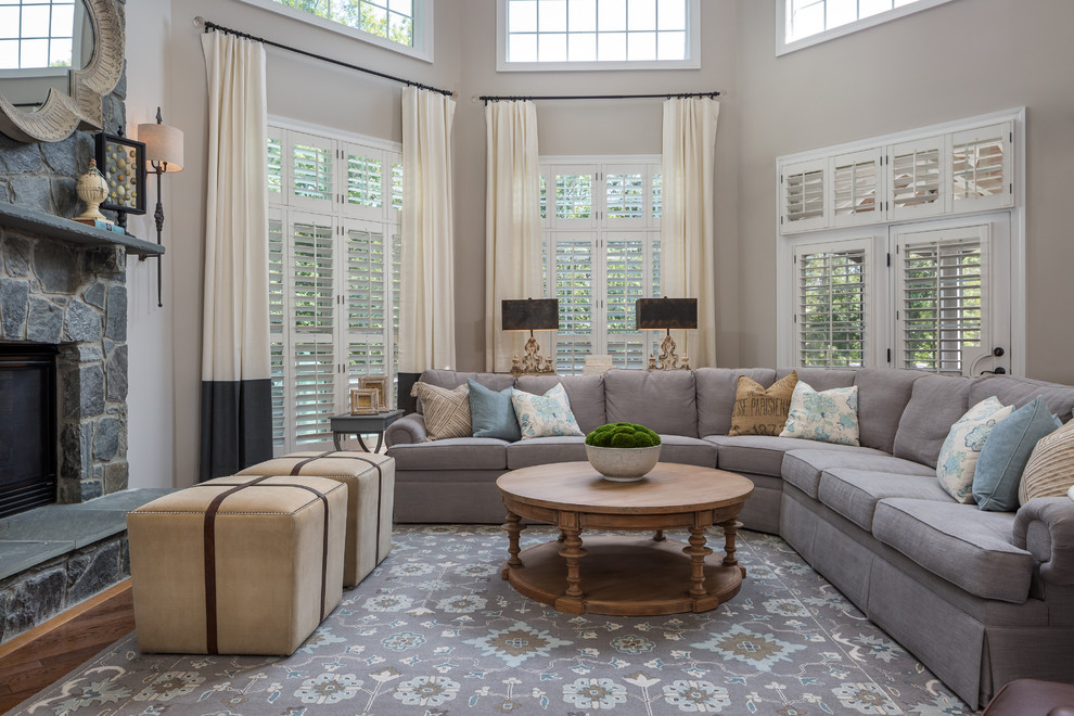 Imagen de sala de estar abierta clásica con paredes beige, suelo de madera oscura, todas las chimeneas, marco de chimenea de piedra y suelo marrón