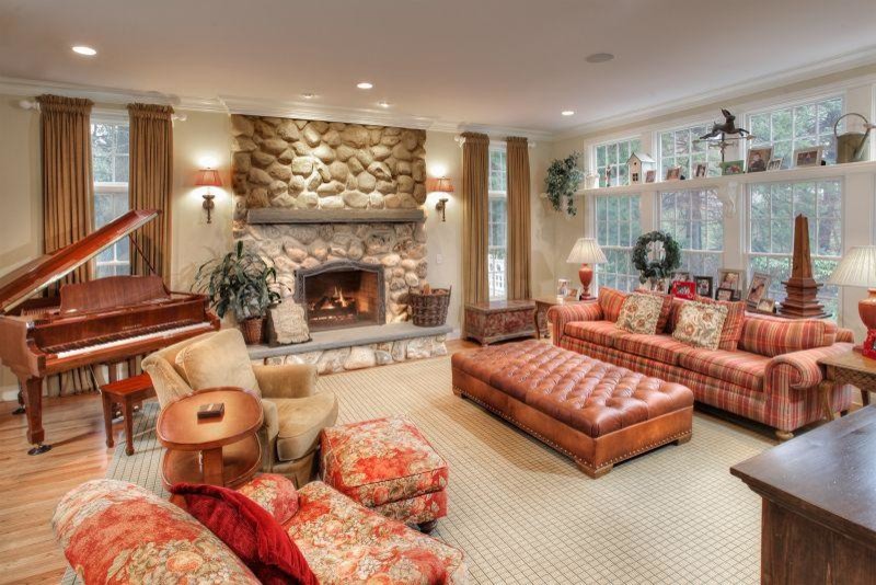Inspiration for a medium sized traditional open plan games room in Las Vegas with beige walls, medium hardwood flooring, a standard fireplace, a stone fireplace surround and a built-in media unit.