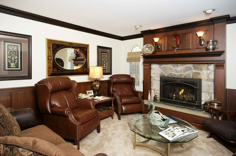 This is an example of a medium sized traditional enclosed games room in Philadelphia with a standard fireplace, a stone fireplace surround and white walls.